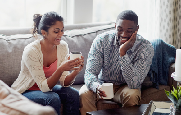 Young couple with coffee in living room